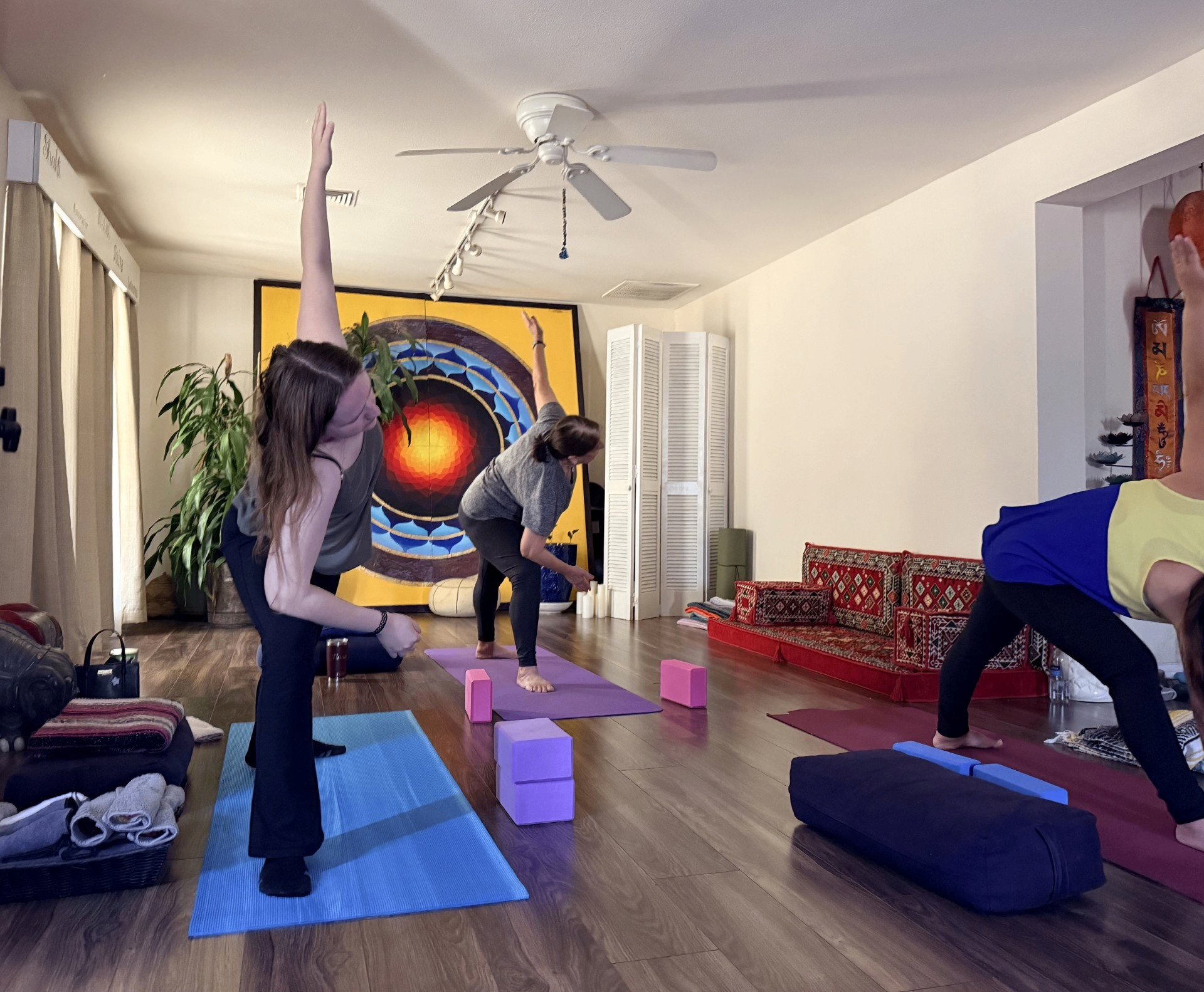 Students practicing beside the mandala mural at Blue Anjou Yoga Studio