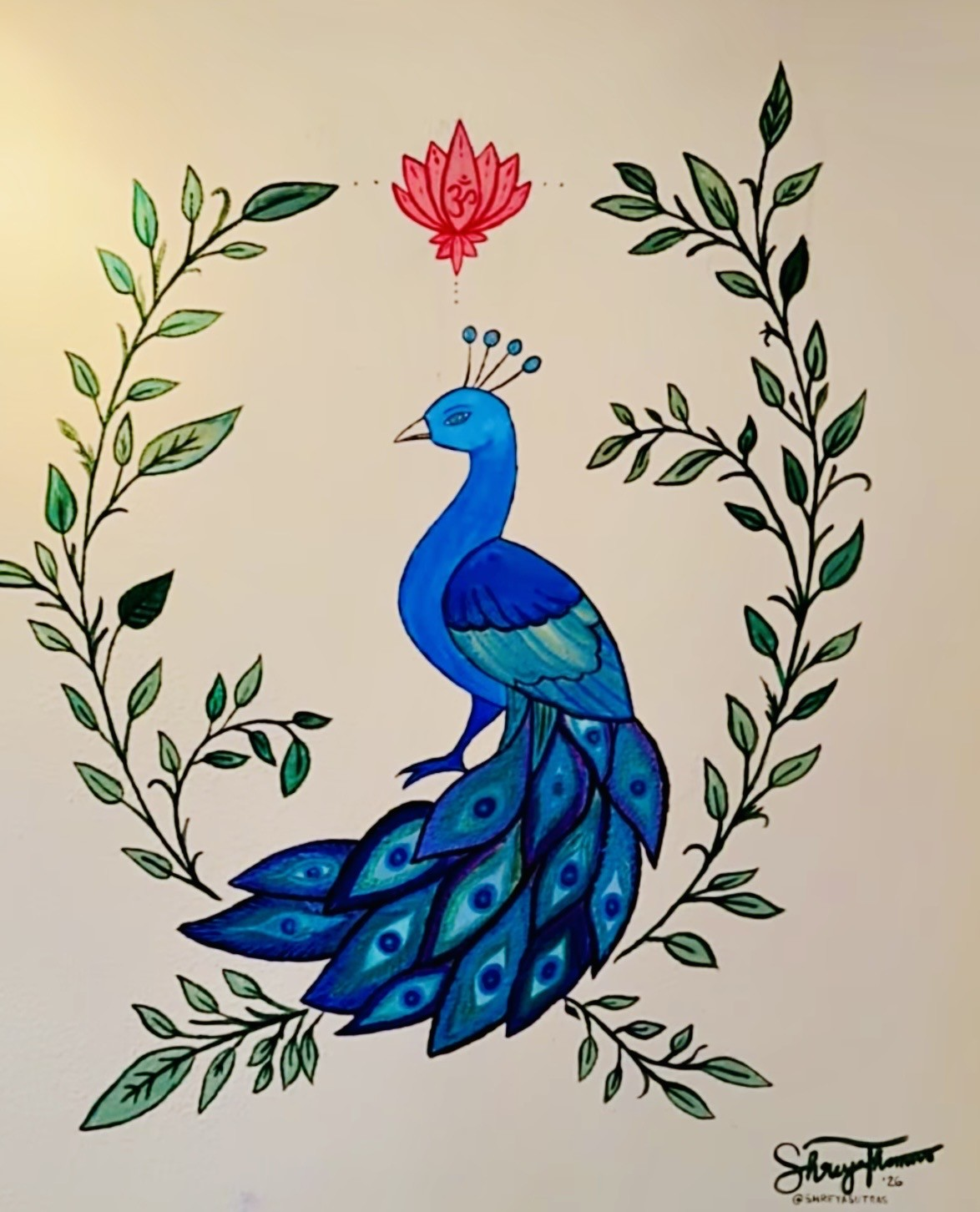 Hand-painted blue peacock artwork with lotus and leaf border at Blue Anjou Yoga Studio