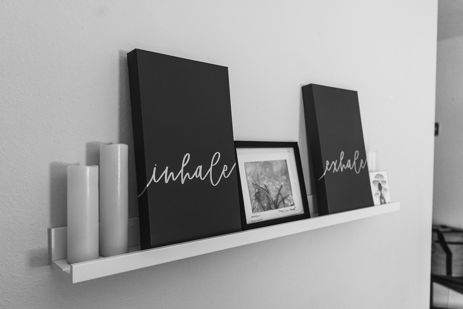Black and white shelf display with candles and inhale and exhale lettering