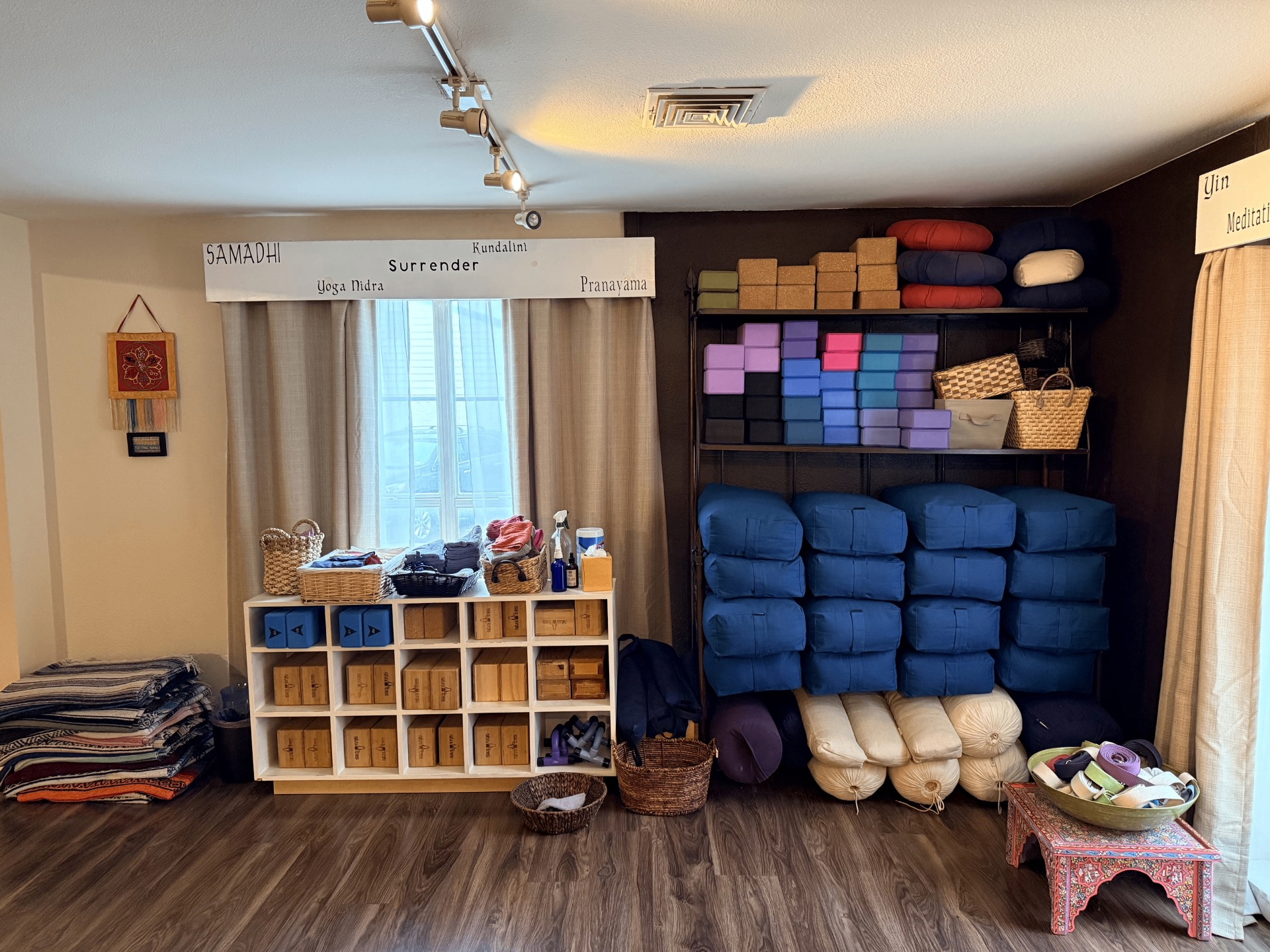 Shelves of blankets, bolsters, cushions, and yoga props inside Blue Anjou Yoga Studio