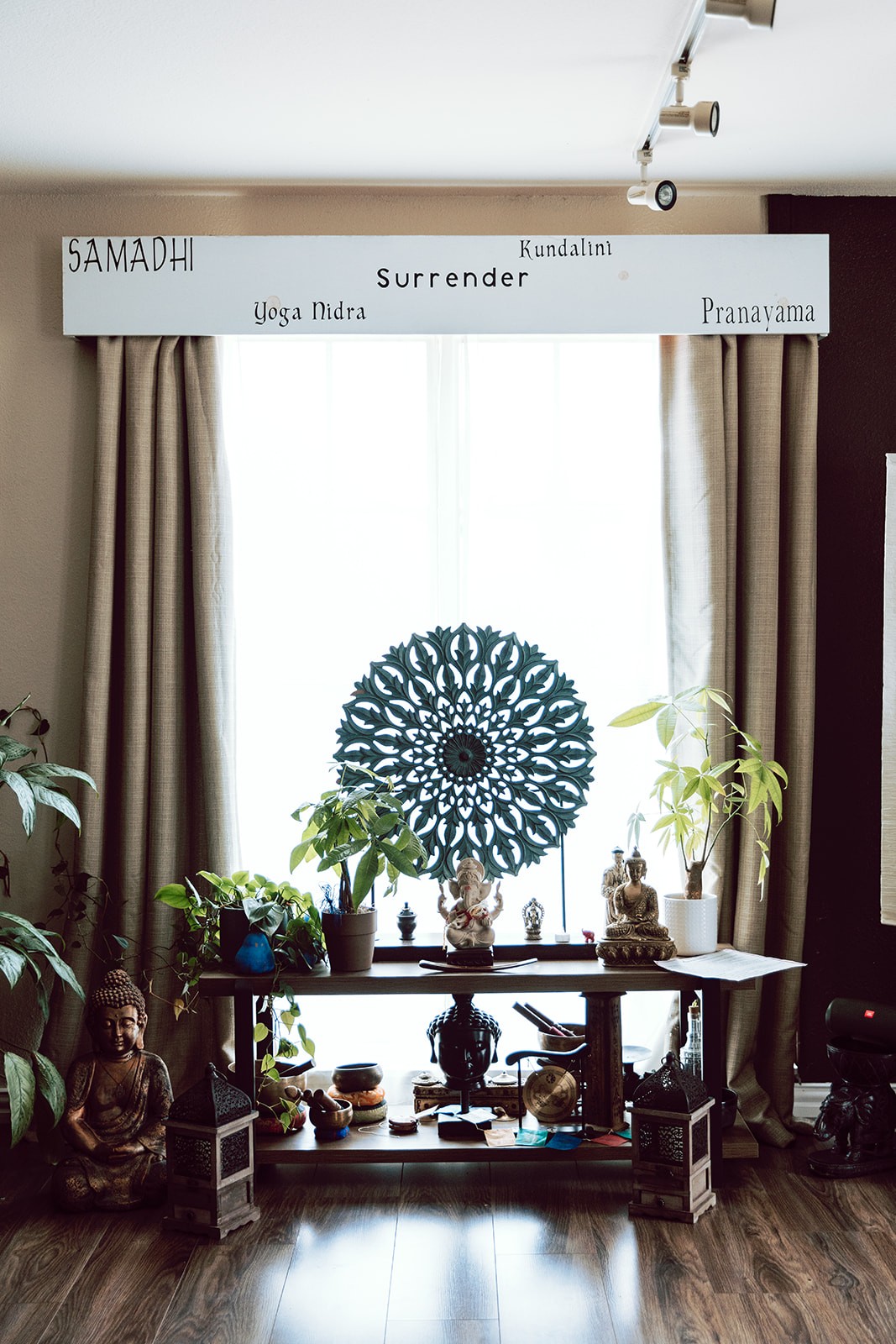 Altar with mandala cloth and candles beneath a Surrender, Samadhi and Pranayama sign
