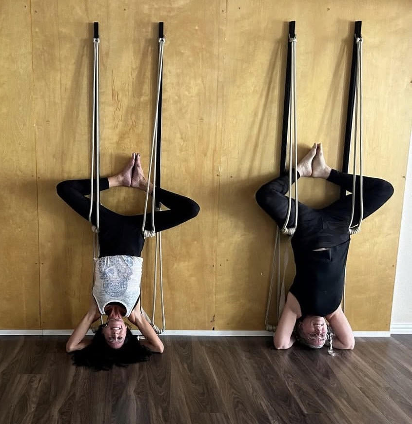 Three students practicing inversions on the Blue Anjou rope wall